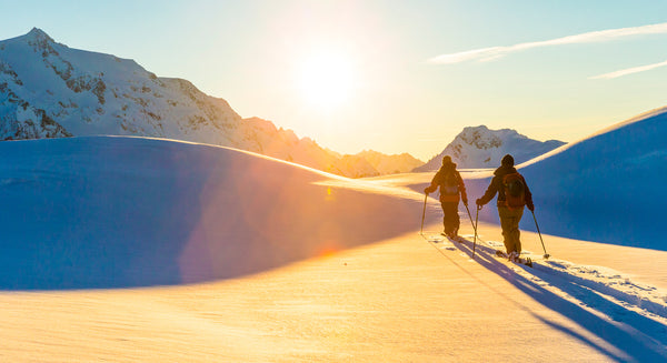 Cross Country Skiers wearing Seirus with mountains in the background